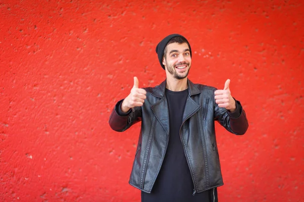 Guapo joven posando en la cámara sobre un fondo rojo . —  Fotos de Stock