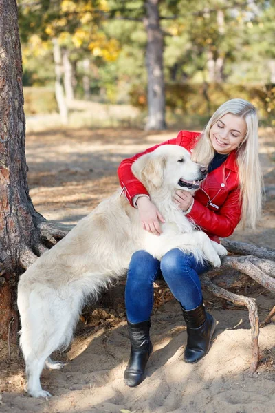 Linda chica rubia paseando con el perro en el bosque. Concepto animal . — Foto de Stock