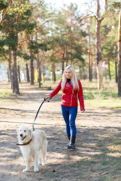 Linda chica rubia paseando con el perro en el bosque. Concepto animal . — Foto de Stock