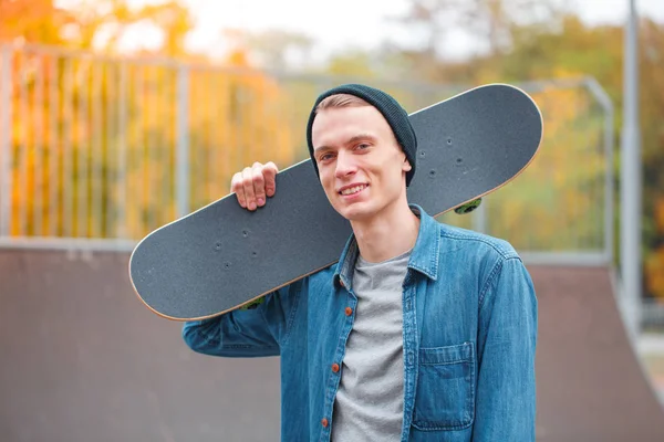 年轻的 skatebarder 摆在滑板的滑板。体育概念. — 图库照片
