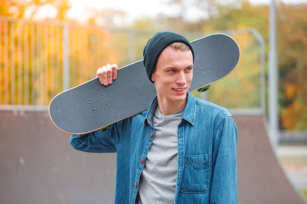 Young skatebarder posing with skateboard in the skatepark. Sport concept. — Stock Photo, Image