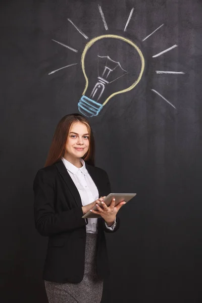成功的年轻女商人用笔记本电脑有一个伟大的想法 在黑板上的灯泡附近的商务女士 — 图库照片