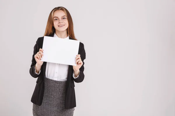 Красивая молодая деловая женщина с белой бумагой на сером фоне. Копирование пространства — стоковое фото