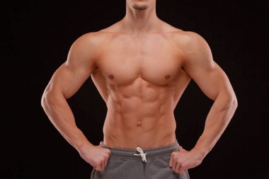 Seksi bir vücut-builder siyah bir arka plan. Bir atlet dramatik portresi. Kurutma. Yardım ve vücudun heykel kas. Sağlıklı yaşam konsepti. Omuz ve sırt kaslarının.