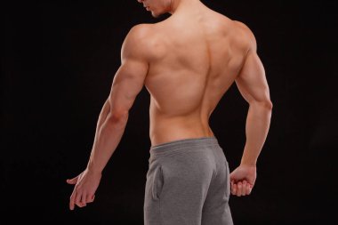 Seksi bir vücut-builder siyah bir arka plan. Bir atlet dramatik portresi. Kurutma. Yardım ve vücudun heykel kas. Sağlıklı yaşam konsepti. Omuz ve sırt kaslarının.