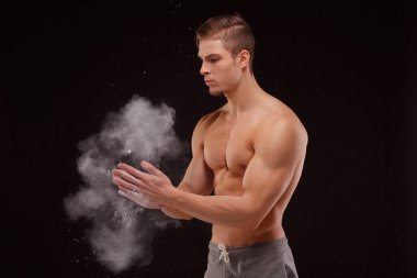 kusursuz bir beden ile yakışıklı sporcu adam ellerini beyaz toz ile smear. Spor kavramı