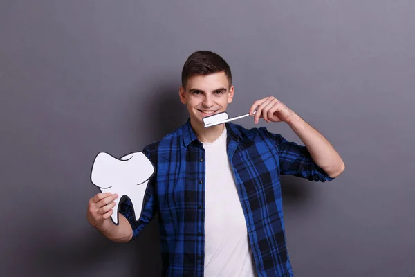 Jovem Segurando Imagem Papel Dente Escova Dentes Fundo Cinza Medicina — Fotografia de Stock