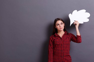 Genç iş kadını beyaz kağıt bulut gri bir arka plan kafasına yakın tutar. Öğrenci kız bir fikri vardır. Fikir kavramı.