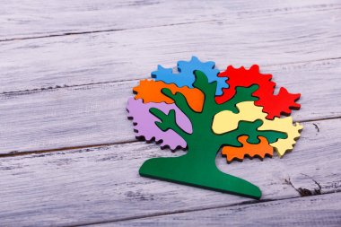 Multicolored tree for playing on the light wooden background. clipart
