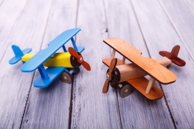 Childrens toy airplanes on the wooden background. Game concept. clipart