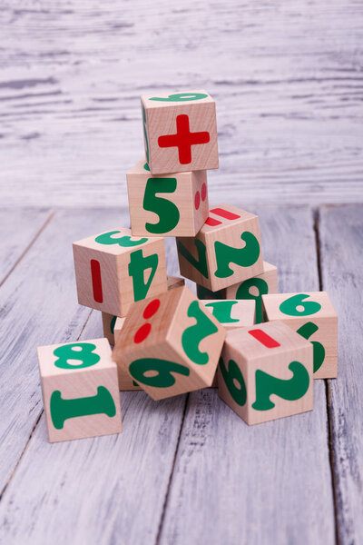 Образовательные деревянные игрушки для детей. Красочные геометрические фигуры на деревянном фоне. Экологические деревянные кубики с числами
.
