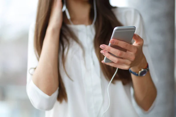 Güzel bir kız onu akıllı bir kafede müzik dinliyor. Yakın çekim kulaklık ile genç bir kadın. Müzik konsepti.