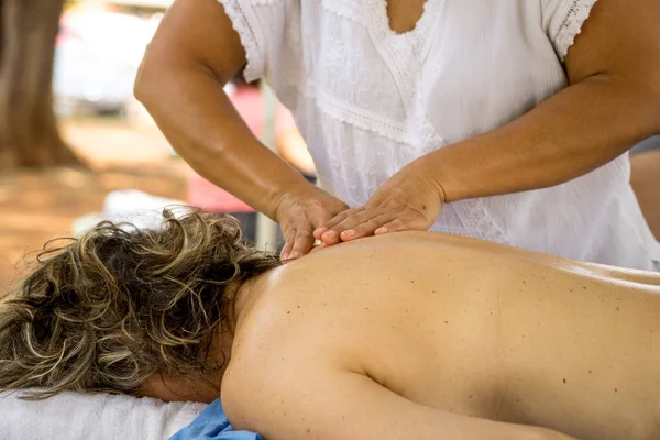 Massage Therapist Massaging a Womens Upper Back at an Outdoor Spa in a Park