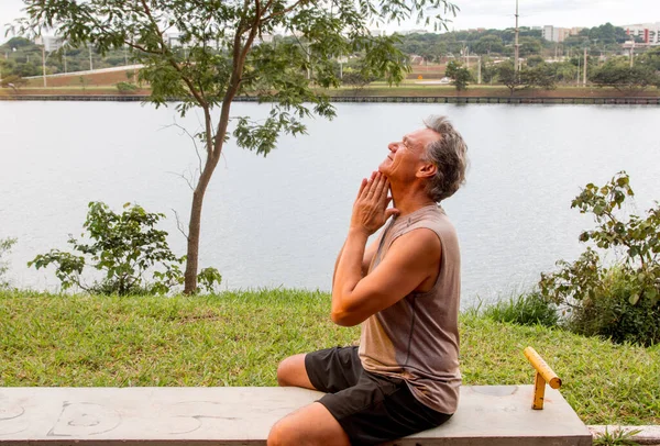 Kıdemli adam spor yaptıktan sonra boynunu geriyor. 