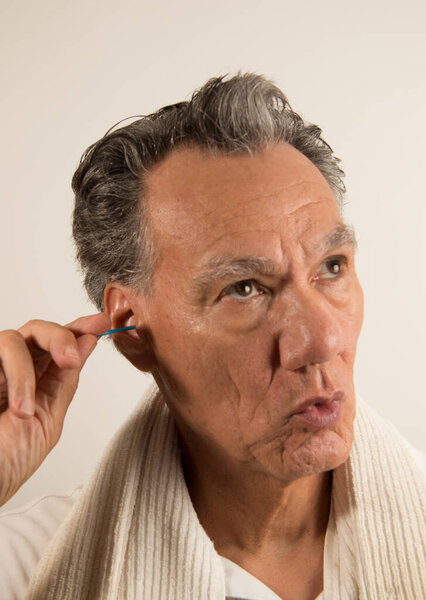 Человек чистит ухо мазком из хлопка.
 