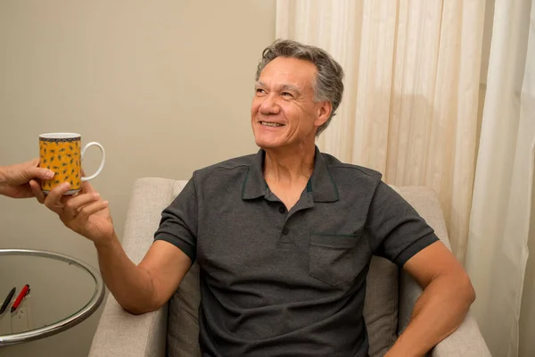 Man Sitting Chair While Someone Hands Him Cup Coffee — Stock Photo, Image