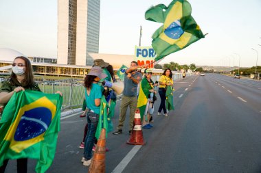 Brasilia, Brezilya-4 Mayıs 2020: Brezilya Cumhurbaşkanı Jair Bolosnaro 'yu destekleyen küçük bir grup, Başkent' teki Senato Binası 'nın önünde bayrak salladı.