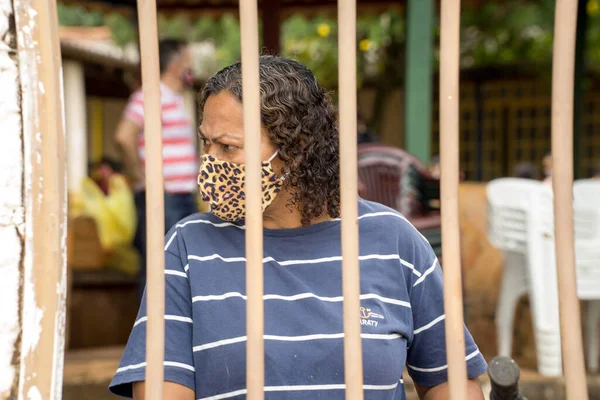 Planaltina, Goias, Brezilya-16 Mayıs 2020: Yerel bir beslenme merkezinde koruyucu maskesini takmış bir kadın