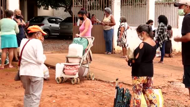 2020年5月16日ブラジル ガイアス州プランティナ 保護マスクを着用し 貧しい人々のための地元の給餌センターで食べ物を待っている間に距離を保つ女性のグループ — ストック動画