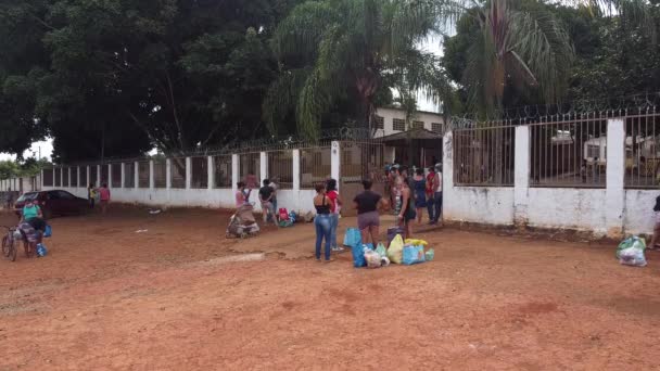 2020年5月16日ブラジル ガイアス州プランティナ 地元の給餌センターで保護マスクを着用しながら食料や衣類を待っている人々のグループ — ストック動画