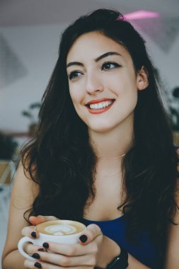 bir kafede gülümseyen kız.