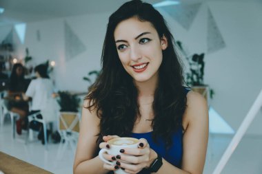 bir kafede gülümseyen kız.