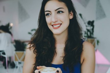 bir kafede gülümseyen kız.