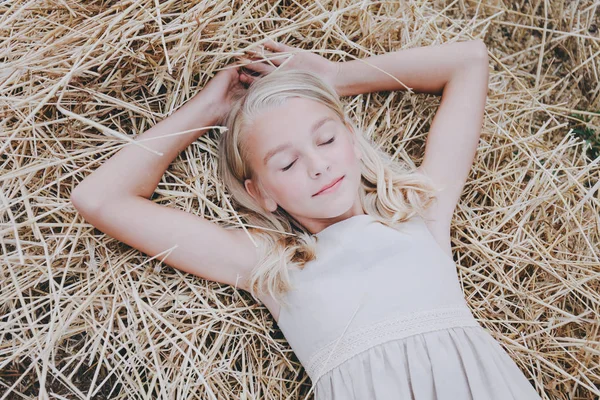 Bir kız bir saman üzerinde yatıyor.