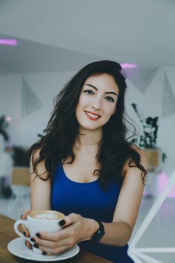 bir kafede gülümseyen kız.