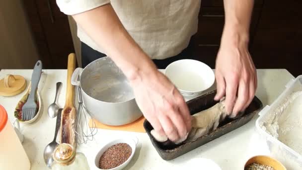 Мужчина пекарь кладет тесто для выпечки — стоковое видео