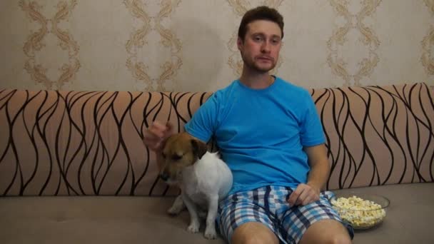 Hombre con perro viendo la televisión — Vídeo de stock