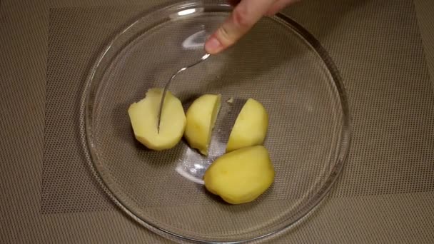 Man mashes aardappelen in een glazen kom — Stockvideo