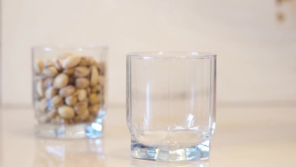 Pistachos. Verter pistachos. Nueces de pistacho cayendo en vidrio — Vídeo de stock