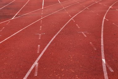 Yakın çekim eğri bir koşu parkuru. Atletizm lane, beyaz çizgisini izlemek ve açın. Futbol sahası çevresinde Atletizm lane.