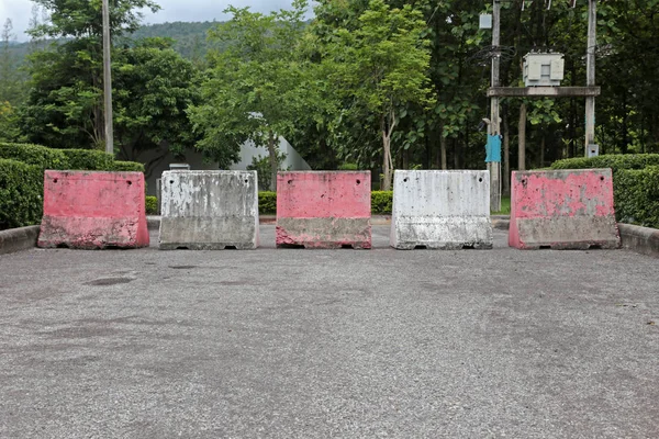 Red and white concrete barriers blocking the road no entry for the car