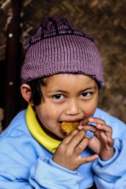 24 Aralık 2008 - Chiangmai Tayland: tatlılar yemek soğuk hava nedeniyle kalın kıyafetler giyen kırsal kız.