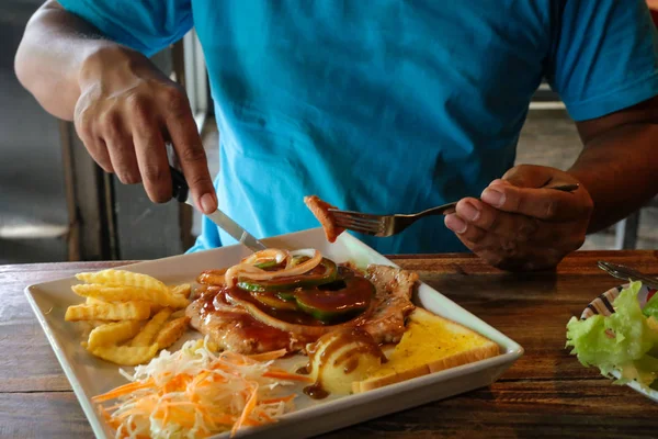 Mavi t-shirt yemek biftek erkeklerde.