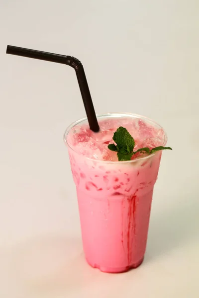 Pink fresh milk in plastic glass — Stock Photo, Image