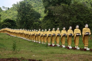 Bir almsbowl tutan bir keşiş gibi güzel Myanmar tapınağında dizilmiş simüle heykeli.