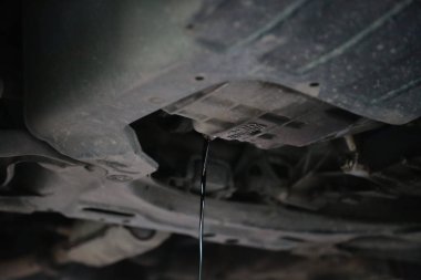 Gelen bir araba altında motor yağ değişimi sırasında drene eski ve kirli motor yağı.