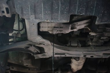 Gelen bir araba altında motor yağ değişimi sırasında drene eski ve kirli motor yağı.