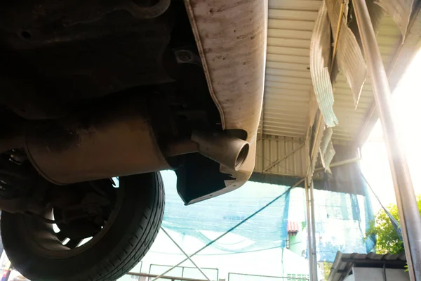 Podvozek vozu a výfukové potrubí v garáži obchodě. — Stock fotografie