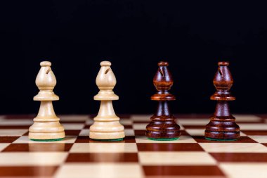 Dört satranç fili siyah bir arkaplanda satranç tahtasında