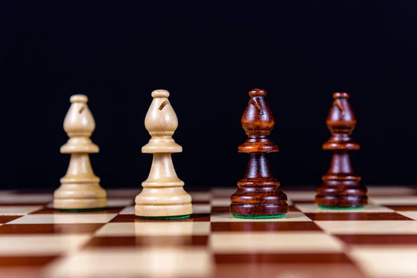 Čtyři Šachoví Biskupové Šachovnici Černém Pozadí — Stock fotografie