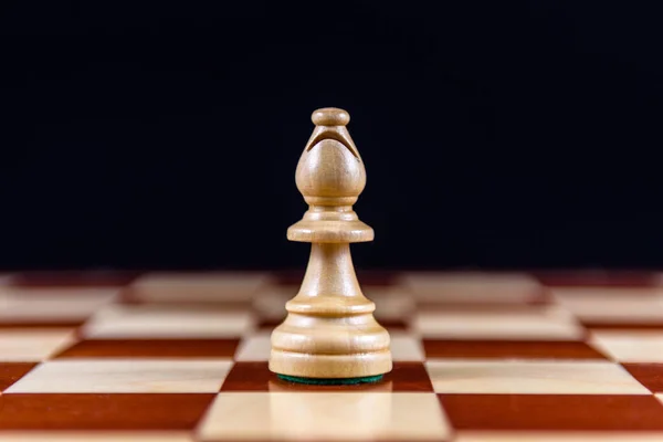 Ein Weißer Schachbischof Steht Auf Einem Schachbrett Auf Schwarzem Hintergrund — Stockfoto