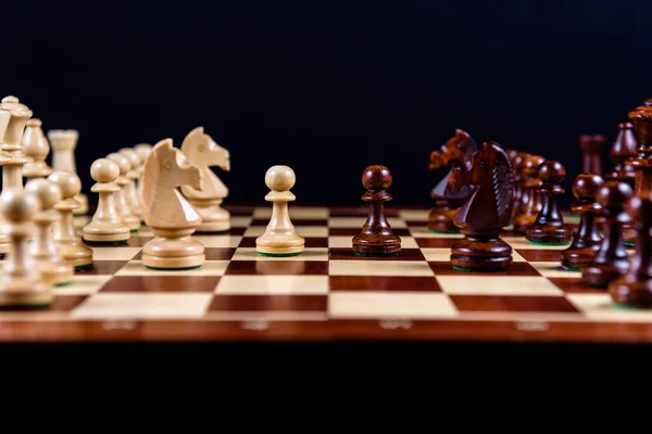 Holzschach Auf Einem Schachbrett Auf Schwarzem Hintergrund Seitenansicht — Stockfoto