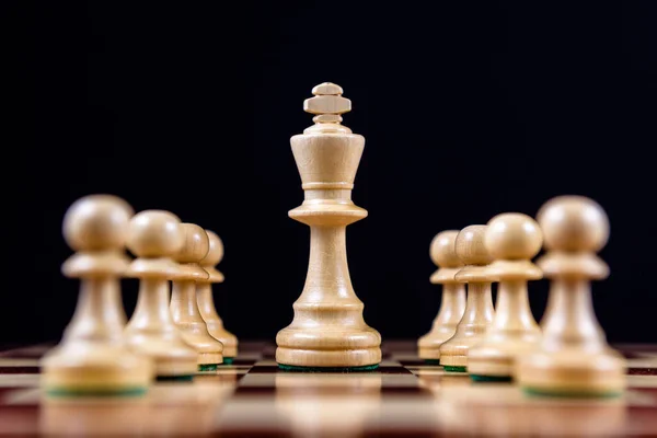 Bílý Šachový Král Mezi Bílými Pěšáky Šachovnici Černém Pozadí — Stock fotografie