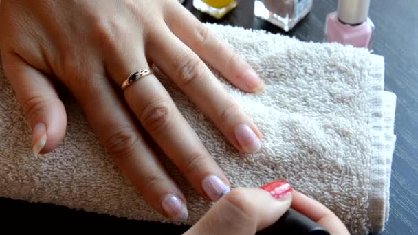 Manicura: hermosas uñas de mujer cuidadas con esmalte de uñas rojo sobre una toalla blanca suave. barniz rojo y nacarado, selecciona uñas — Vídeo de stock