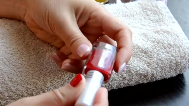 Manicura: hermosas uñas de mujer cuidadas con esmalte de uñas rojo sobre una toalla blanca suave. barniz rojo y nacarado, selecciona uñas — Vídeo de stock