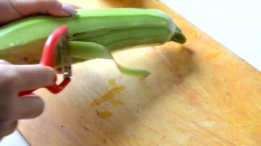 Bir kız yahni, salata ya da çorba yapmak için kabak soyar ve keser. vejetaryen, çiğ yemek, diyet, kilo kaybı